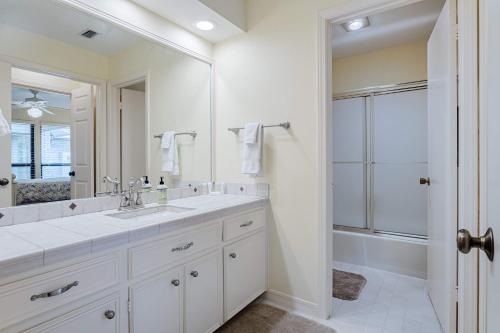 a white bathroom with a sink and a shower at Waterfront Home on Lake Travis in Lakeway