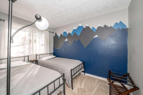 a bedroom with two beds with mountains painted on the wall at Cozy Home Away From Home in Florence