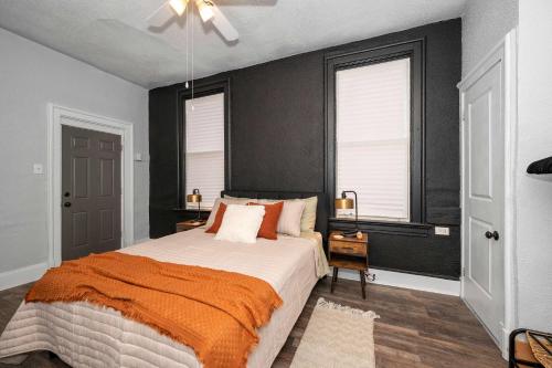 a bedroom with a large bed and two windows at Stylish Modern Gem in the HIlls in Cincinnati