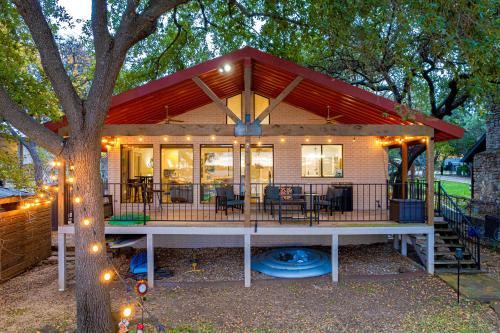 a house with a red roof and a tree at Lake LBJ Waterfront Family-Friendly Retreat in Granite Shoals