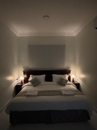 アル・コバールにあるشقة مودرن دخول ذاتيのベッドルーム1室(大型ベッド1台、ランプ2つ付)