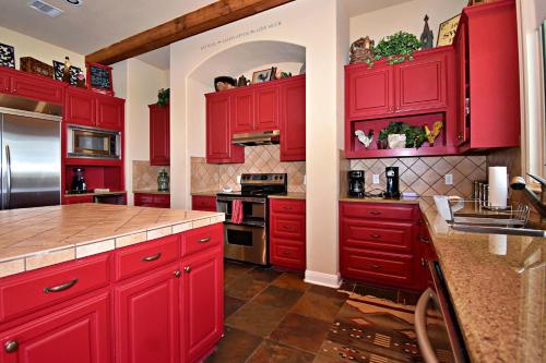 a red kitchen with red cabinets and appliances at Pet-Friendly Oasis in Gated Community in Spicewood