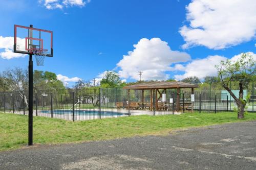 a basketball hoop in a park with a pool at Pet-Friendly Oasis in Gated Community in Spicewood