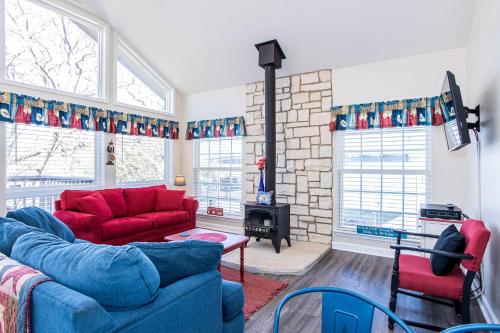 a living room with two red couches and a fireplace at Pet Friendly Retreat on Lake LBJ in Burnet