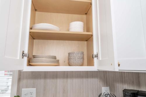 a kitchen cabinet with plates and dishes in it at Covington Charm 201 in Covington