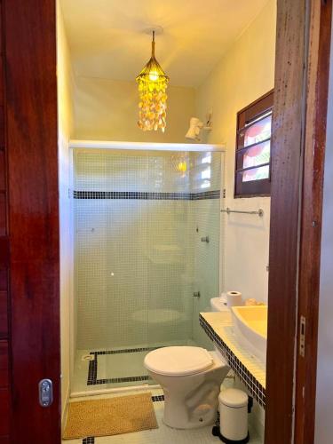 a bathroom with a glass shower with a toilet and a sink at The Wind Village in Itarema