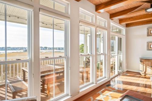a large room with windows and a table and a balcony at Hidden Paradise - Coastal Views in Ocean View
