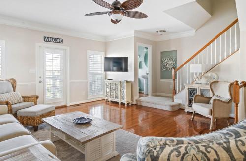 a living room with white furniture and a ceiling fan at Hidden Paradise - Coastal Views in Ocean View