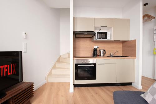 a small kitchen with a stove and a sink at Le Bohème - T2 Centre Ville CLIM Parking in Albi
