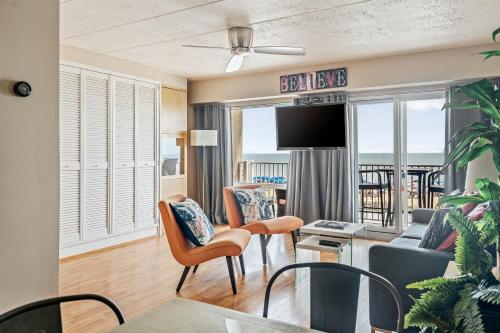 a living room with a couch and chairs and a tv at Seaside Star - On The Boardwalk in Rehoboth Beach