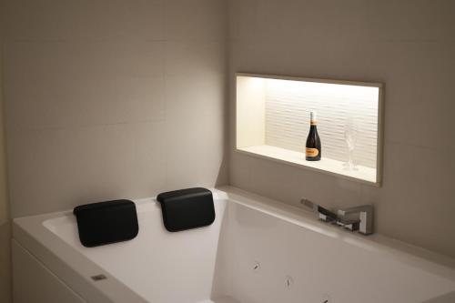 a bathroom with a sink and a bottle of wine at DR Luxury Apartments in Avola