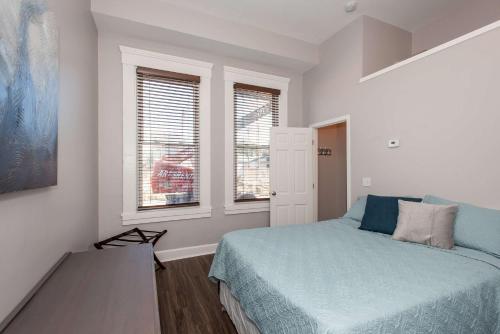 Un dormitorio con una cama y dos ventanas. en Heart of Mainstrasse 1, en Covington