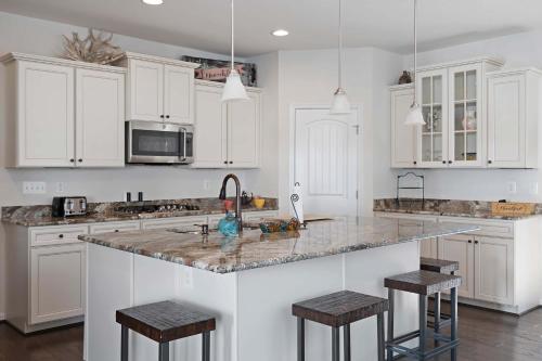 a kitchen with white cabinets and a granite counter top at Ocean View Beach Club - Bennetts in Ocean View
