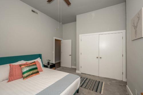 a white bedroom with a bed and a white closet at The Heart of Madison Suites in Covington
