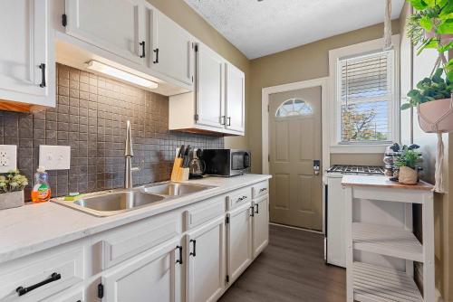 a kitchen with white cabinets and a sink at Merion Village Residences - Escape the Hustle & Bustle in Columbus