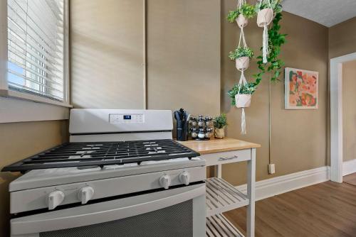 a kitchen with a stove and some potted plants at Merion Village Residences - Escape the Hustle & Bustle in Columbus