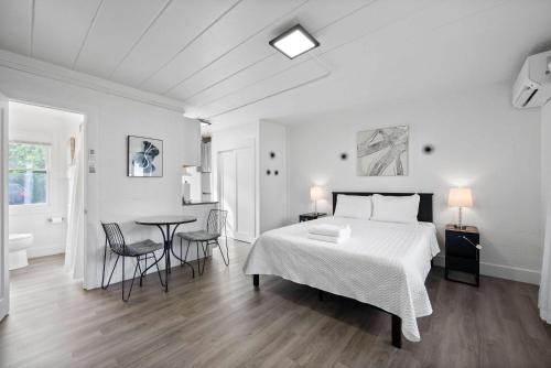 a white bedroom with a bed and a table and chairs at Chic City Retreat 93I in Columbus