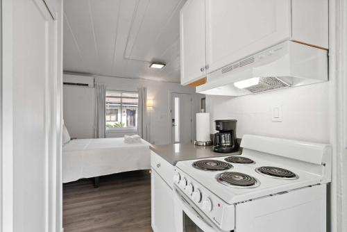 a white kitchen with a stove and a bed at Chic City Retreat 93I in Columbus