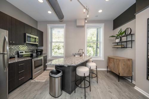 a kitchen with a island in the middle of it at Queen City Views 3 Chic 2 BDR in Cincinnati