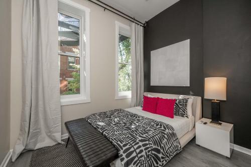 a bedroom with a bed with red pillows and a window at Queen City Views 2 Sleeps 2 in Cincinnati
