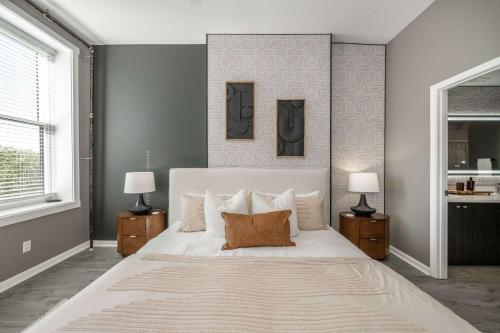 a bedroom with a large white bed with two lamps at Queen City Views 4 Chic Apt in Cincinnati
