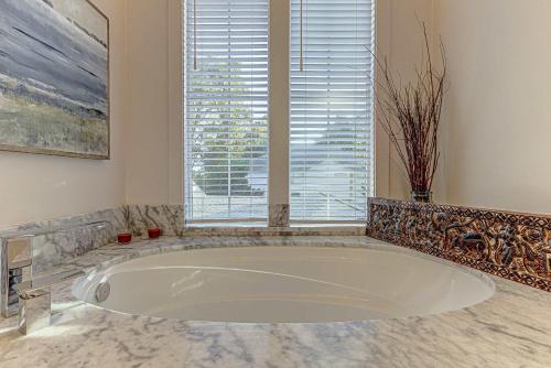 a large white tub in a bathroom with a window at Immaculate Waterfront Family Home for 16 w Private Dock in Kingsland