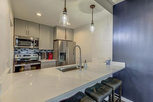 a kitchen with a sink and a counter with bar stools at Cozy 3 bdr family Condo in Horseshoe Bay Near Marina in Horseshoe Bay