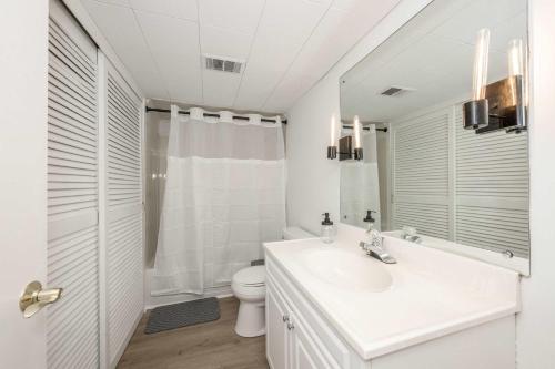 a white bathroom with a sink and a toilet at The Grand Elm Suites in Ludlow