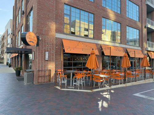 a restaurant with chairs and umbrellas in front of a building at Bridge Park Luxe in Dublin