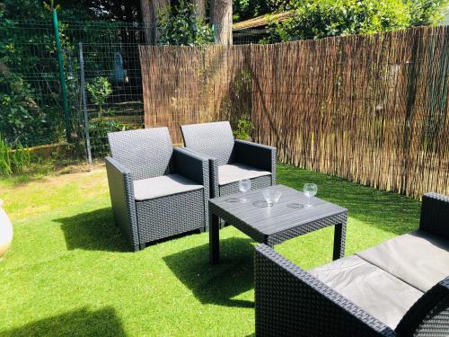 a patio with two chairs and a table on the grass at Studio in Boucau