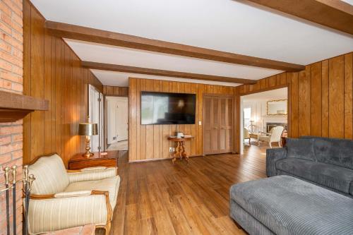 Una sala de estar con un sofá y un televisor. en Tallen Manor & Retreat, en Hamilton