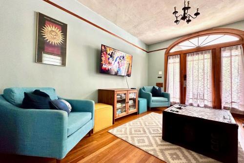 a living room with two blue couches and a table at Mid City 2 BR- beautiful, renovated Arts & Crafts Flat in New Orleans