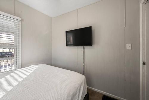 a bedroom with a bed and a flat screen tv on the wall at The Cozy Bellows - Retreat for 4 in Columbus