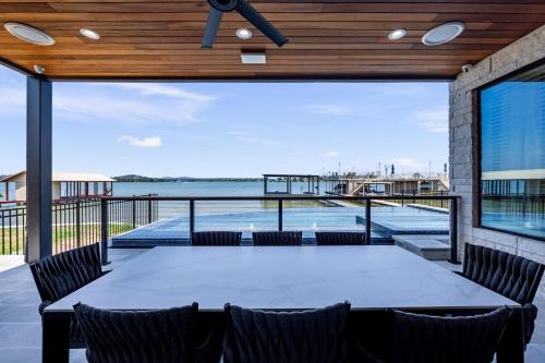 a patio with a table and chairs and a view of the water at Lakefront Stay for 16 with Pool Dock & Game Room in Granite Shoals