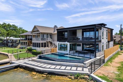 a home with a swimming pool and a house at Lakefront Stay for 16 with Pool Dock & Game Room in Granite Shoals