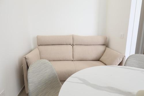 a living room with a couch and a table and chairs at DR Luxury Apartments in Avola