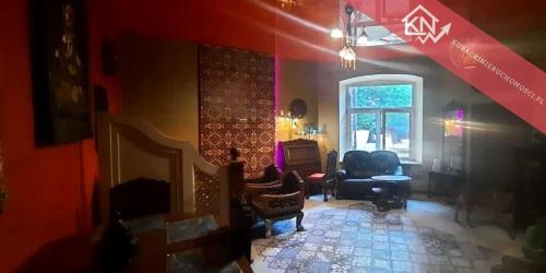 a living room with a fireplace and a red wall at Sekret Maharadży - The Maharaja's Secret in Częstochowa