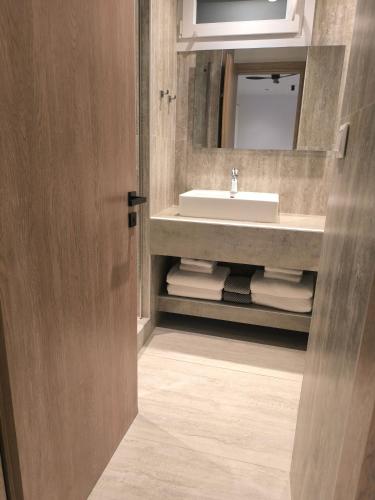 a bathroom with a sink and a mirror at Down Town Skiathos in Skiathos