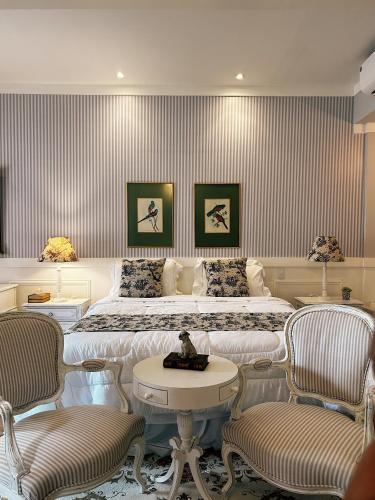a hotel room with two beds and two chairs at La Belle Provence in Itaipava
