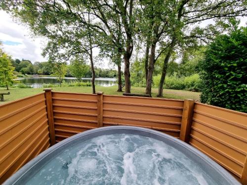 a glass orb on a fence with a pond at Maple Lodge 11 Hot Tub & Sauna in York