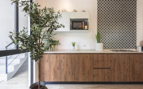 a kitchen with a wooden cabinet and a mirror at Alkimya Stylish Haven by LAHOS in Mérida