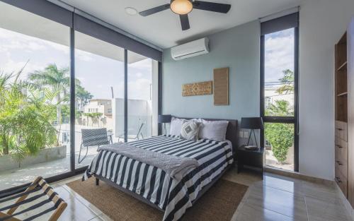 a bedroom with a bed and a ceiling fan at Alkimya Stylish Haven by LAHOS in Mérida
