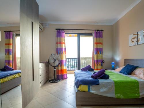 1 dormitorio con 2 camas y balcón en SeaView Apartment in Saint Thomas Bay, en Marsaskala