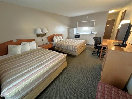 a hotel room with two beds and a desk at FairBridge Extended Stay, a Kitchenette Hotel in Idaho Falls