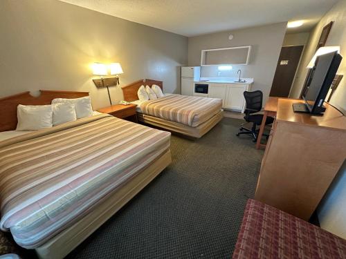 a hotel room with two beds and a desk at FairBridge Extended Stay, a Kitchenette Hotel in Idaho Falls