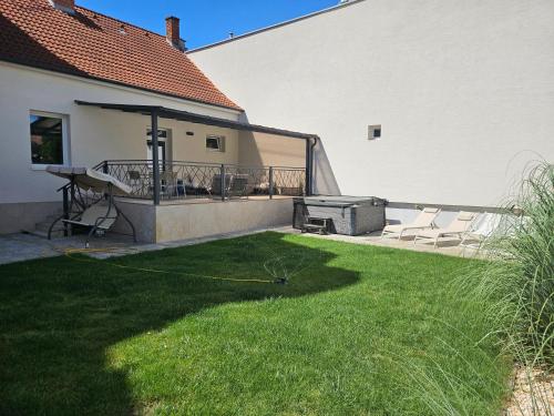 a yard with a grill and chairs on a balcony at Apartmán VAJANA Exclusiv & Jacuzzi in Piešťany