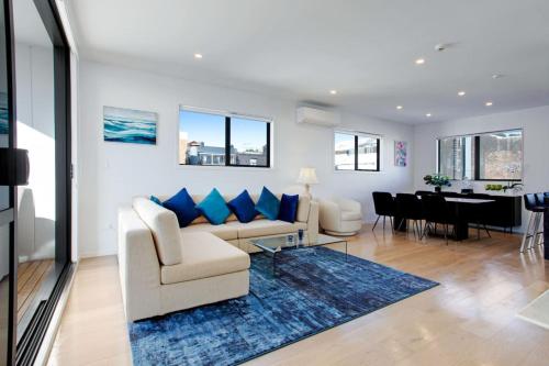 a living room with a couch and a dining room at Central Modern Duplex Home near Cornwall Park in Auckland