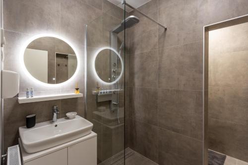 a bathroom with a shower and a sink and a mirror at Vila Slovenka in Celje