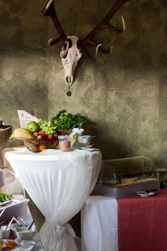 a table with fruits and vegetables on it with a deer skull on the wall at Seybolds Gästehaus in Lauffen am Neckar