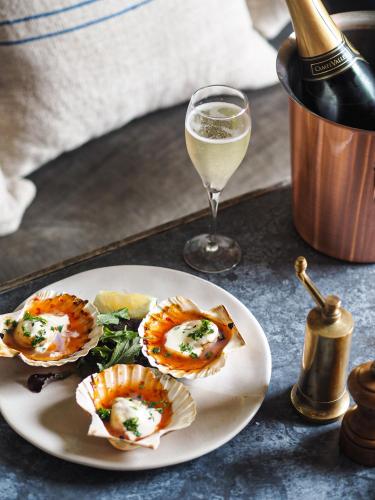a plate of food and a glass of wine at Artist Residence Cornwall in Penzance